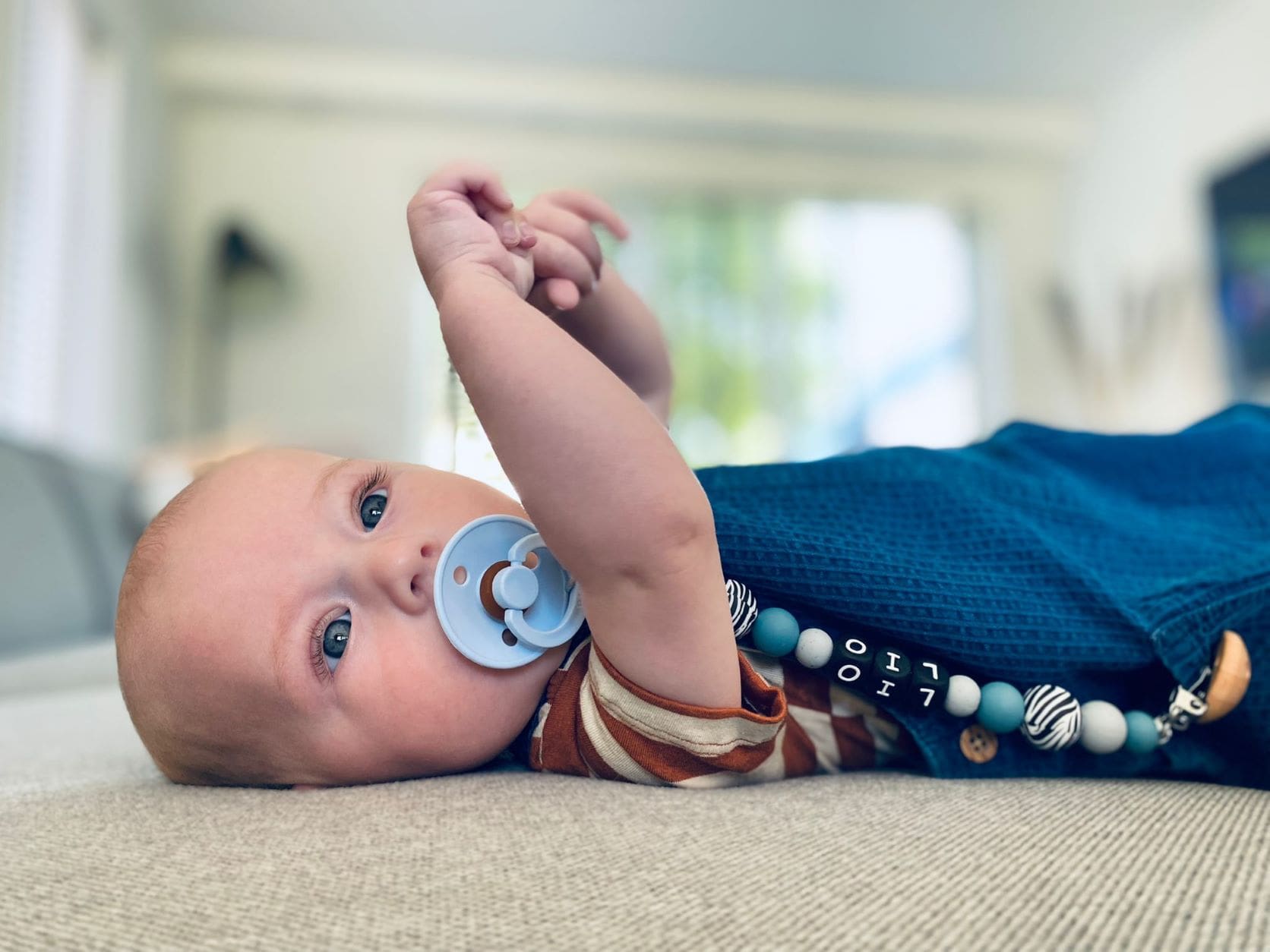 Kindje met speen en blauwe fopspeenkoord van Studio Bambacht