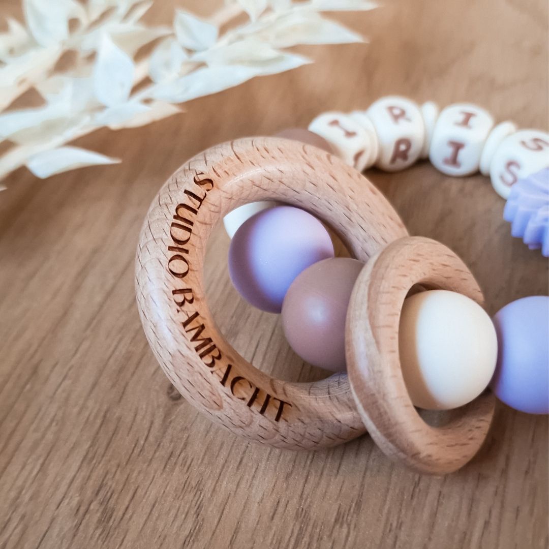 Bijtring met naam siliconen in de kleur lila met bloem kraal handgemaakt kraamcadeau met naam van Studio Bambacht