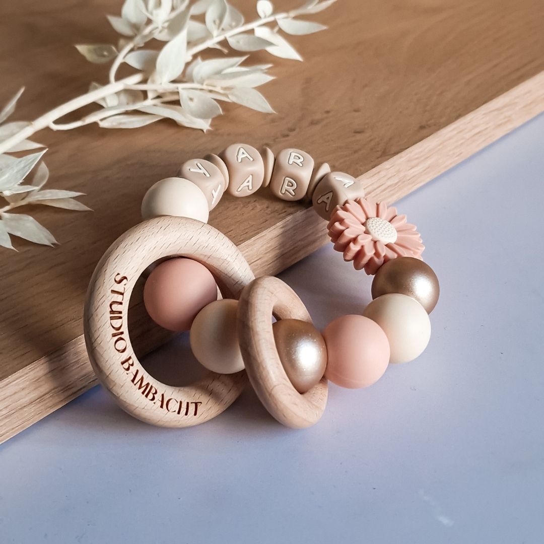 Bijtring met naam madelief in de kleur zalmroze handgemaakt door Iris van Studio Bambacht