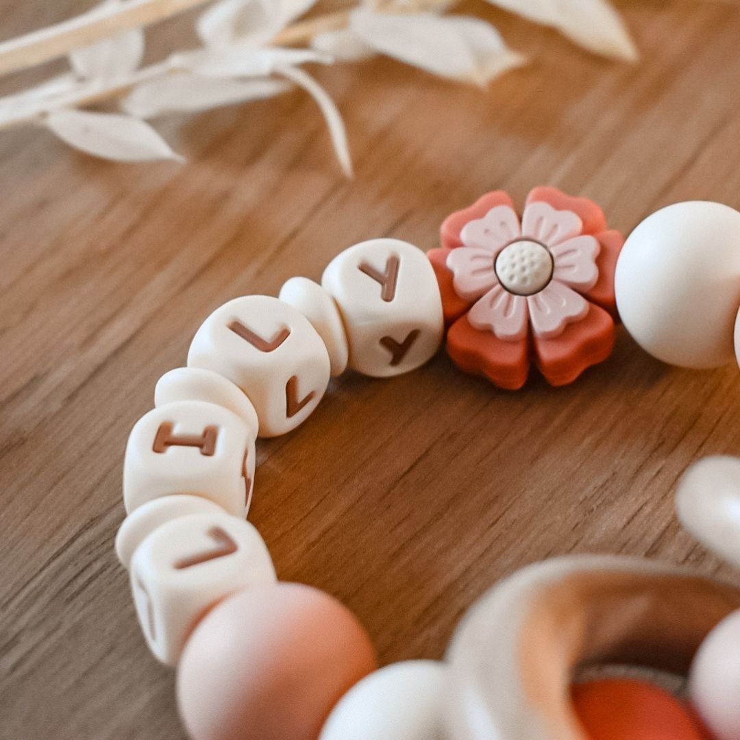 Studio Bambacht bijtring met naam in de kleur donker zalmroze met bloem
