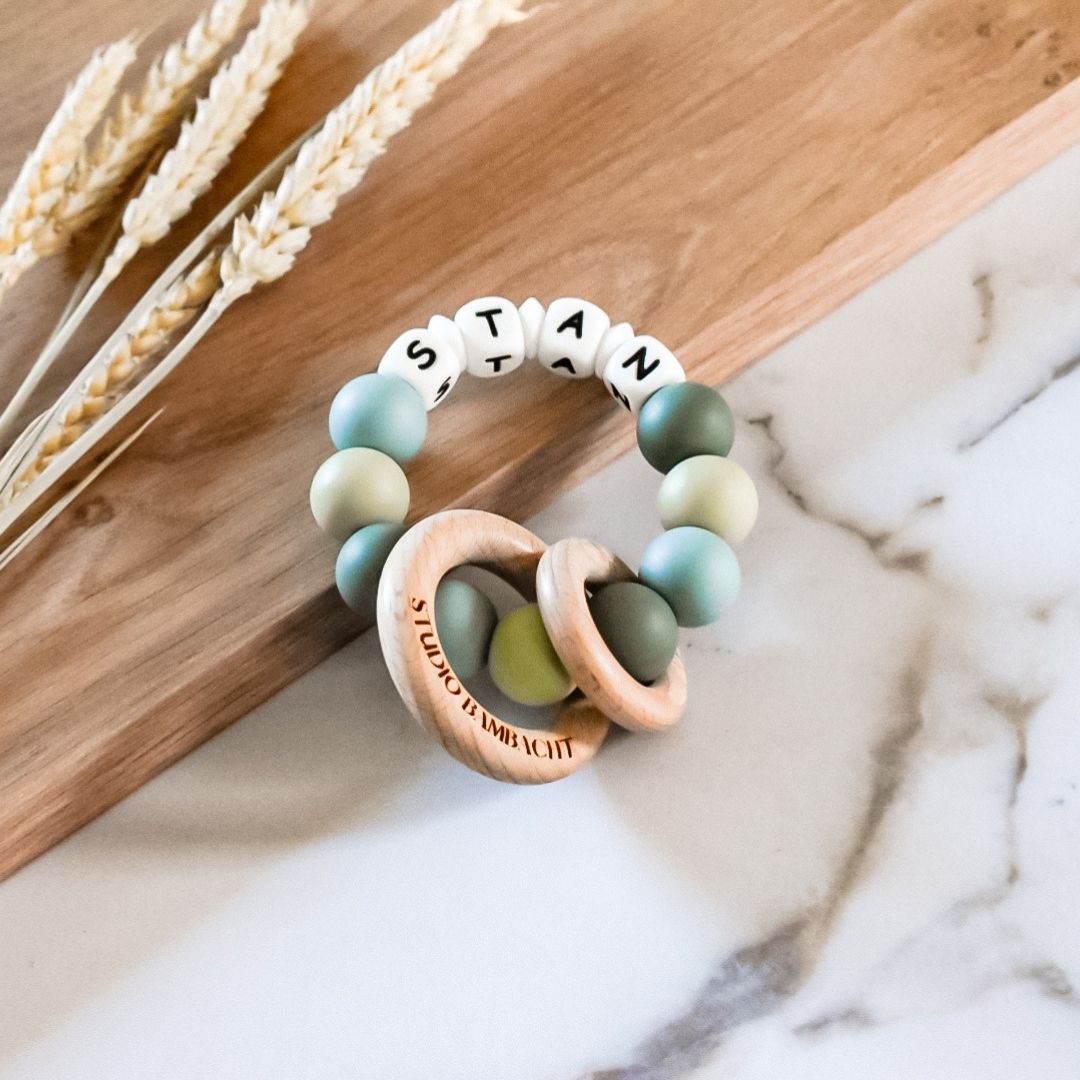 Bijtring met naam in de kleuren blauw en groen handgemaakt kraamcadeau met naam door Iris van Studio Bambacht