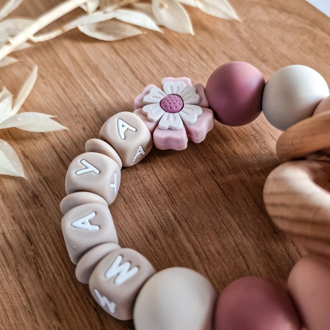 Bijtring met naam meisje lichtroze bloem handgemaakt kraamcadeau van Studio Bambacht