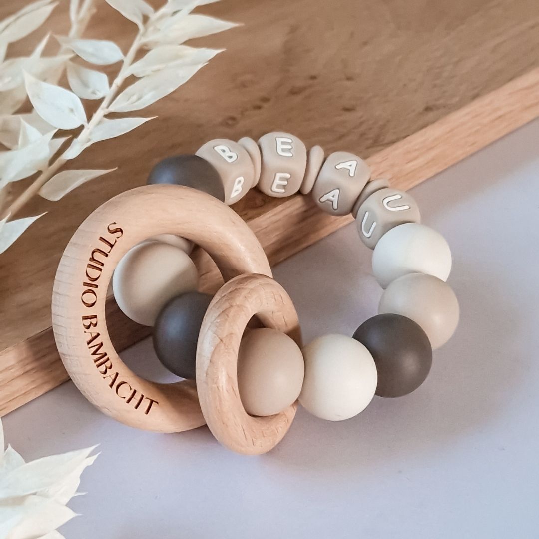 Bijtring met naam neutraal donker beige van siliconen kralen handgemaakt kraamcadeau met naam door Studio Bambacht