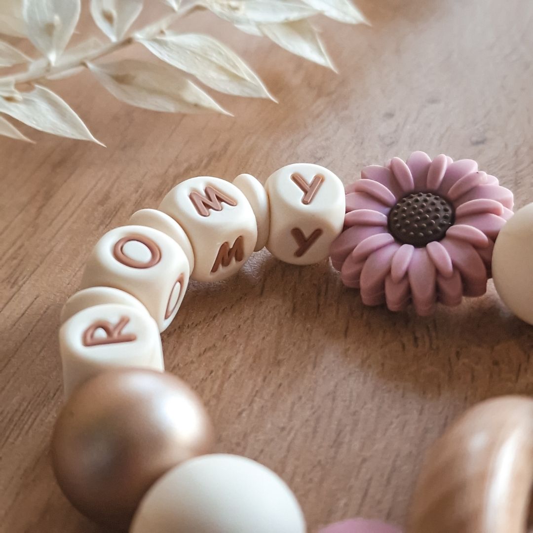 Bijtring met naam roze met madelief handgemaakt kraamcadeau door Iris van Studio Bambacht