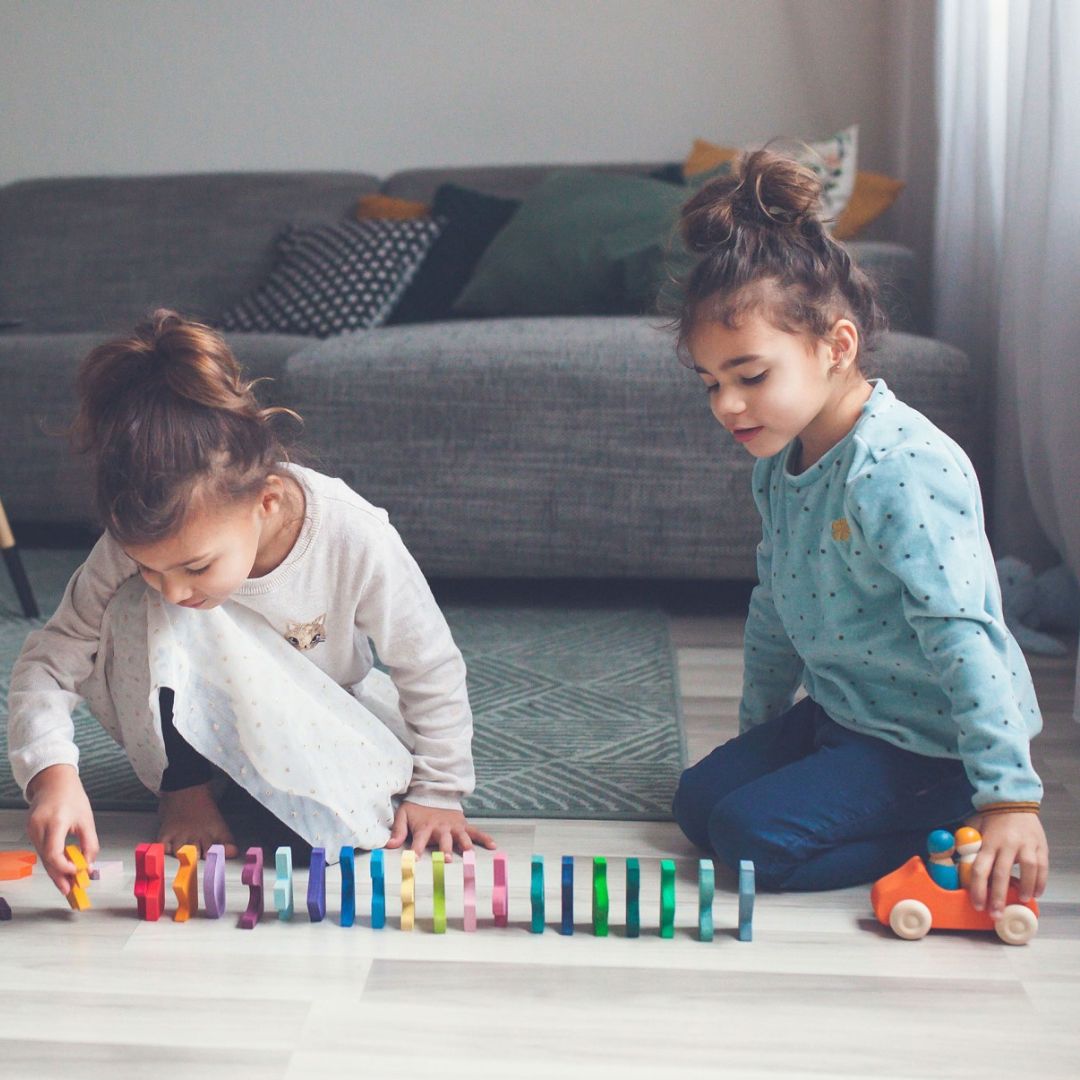 Grimm's houten speelgoed auto in de kleur oranje met twee houten poppetjes