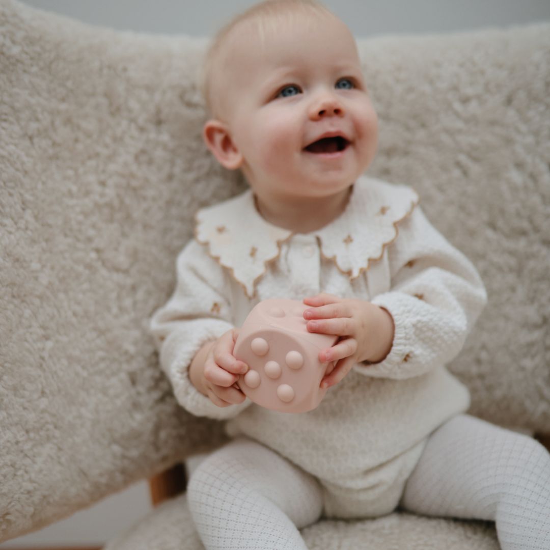 Mushie bijtspeelgoed press toy dobbelsteen shifting sand wit en blush roze