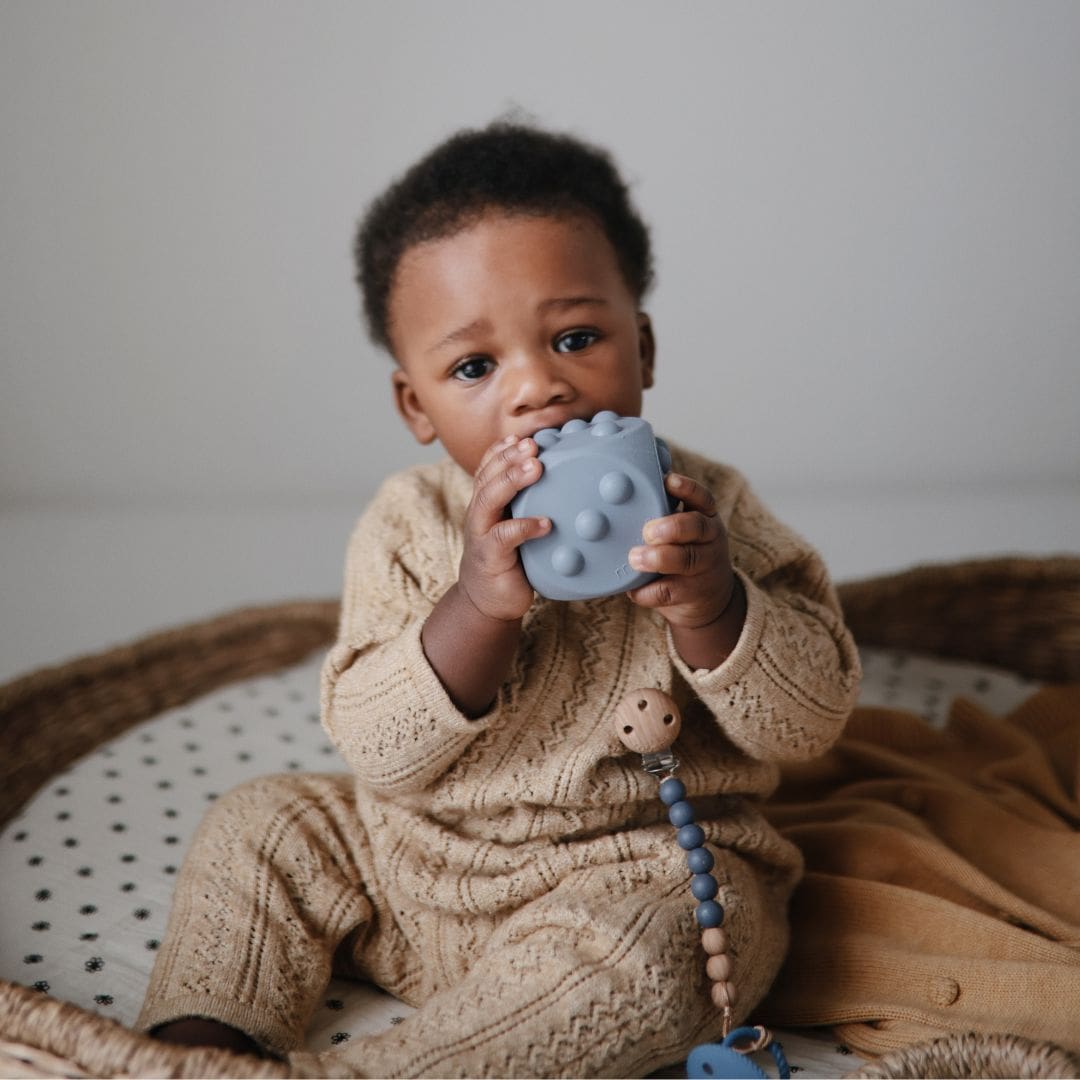 Mushie bijtspeelgoed press toy dobbelsteen in de kleur stone lichtgrijs en tradewinds grijs