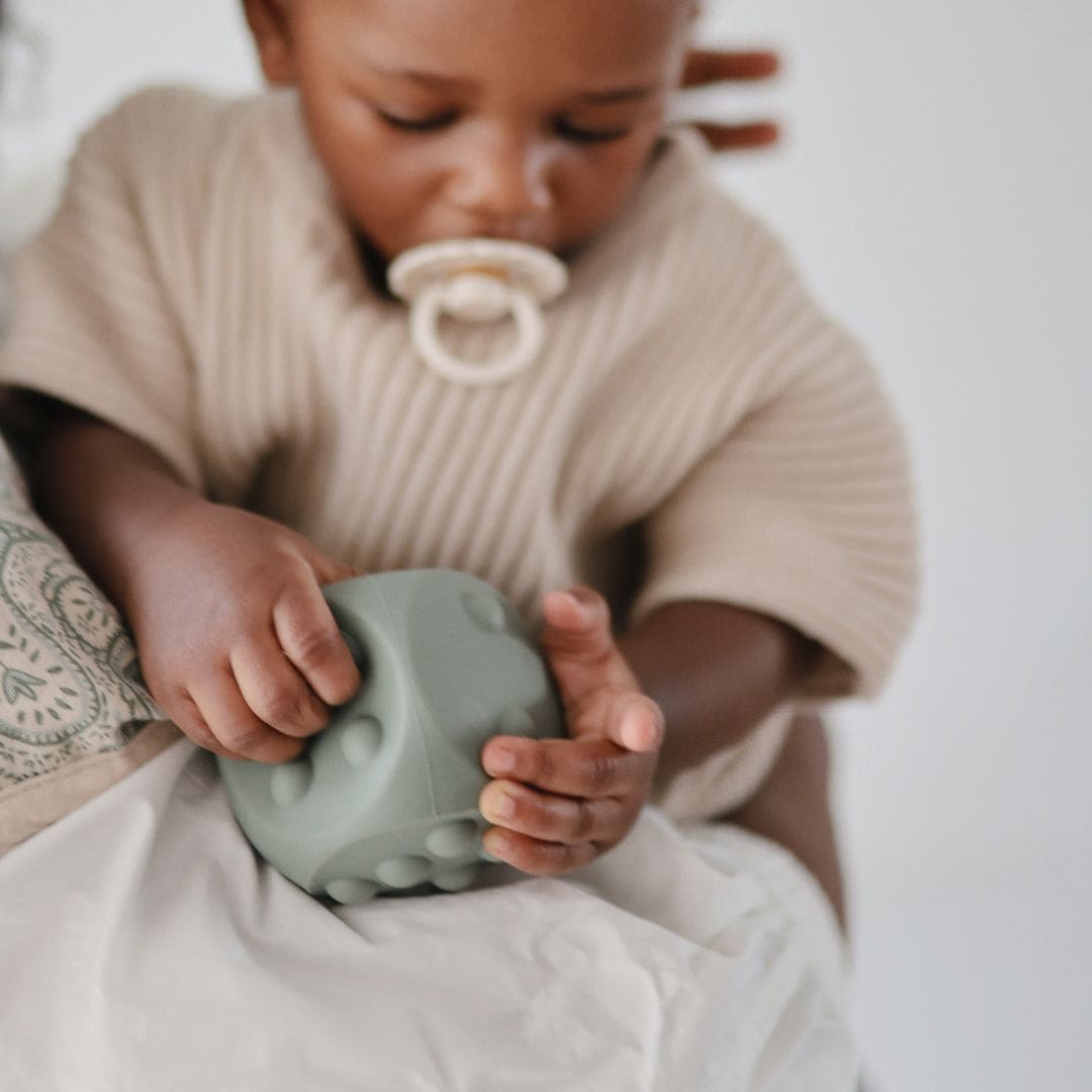 Mushie bijtspeelgoed press toy dobbelsteen shifting sand wit en Cambridge blue groen