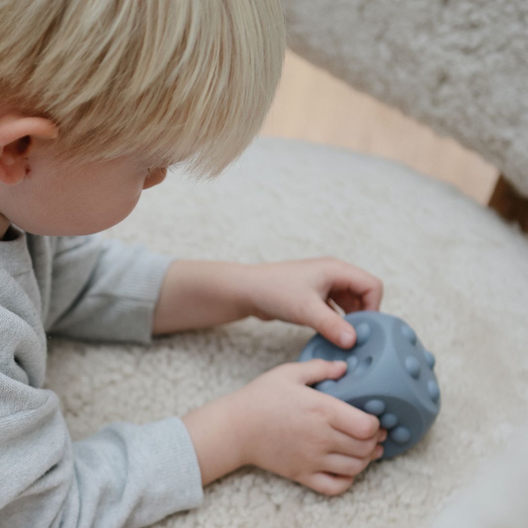 Mushie bijtspeelgoed press toy dobbelsteen in de kleur stone lichtgrijs en tradewinds grijs