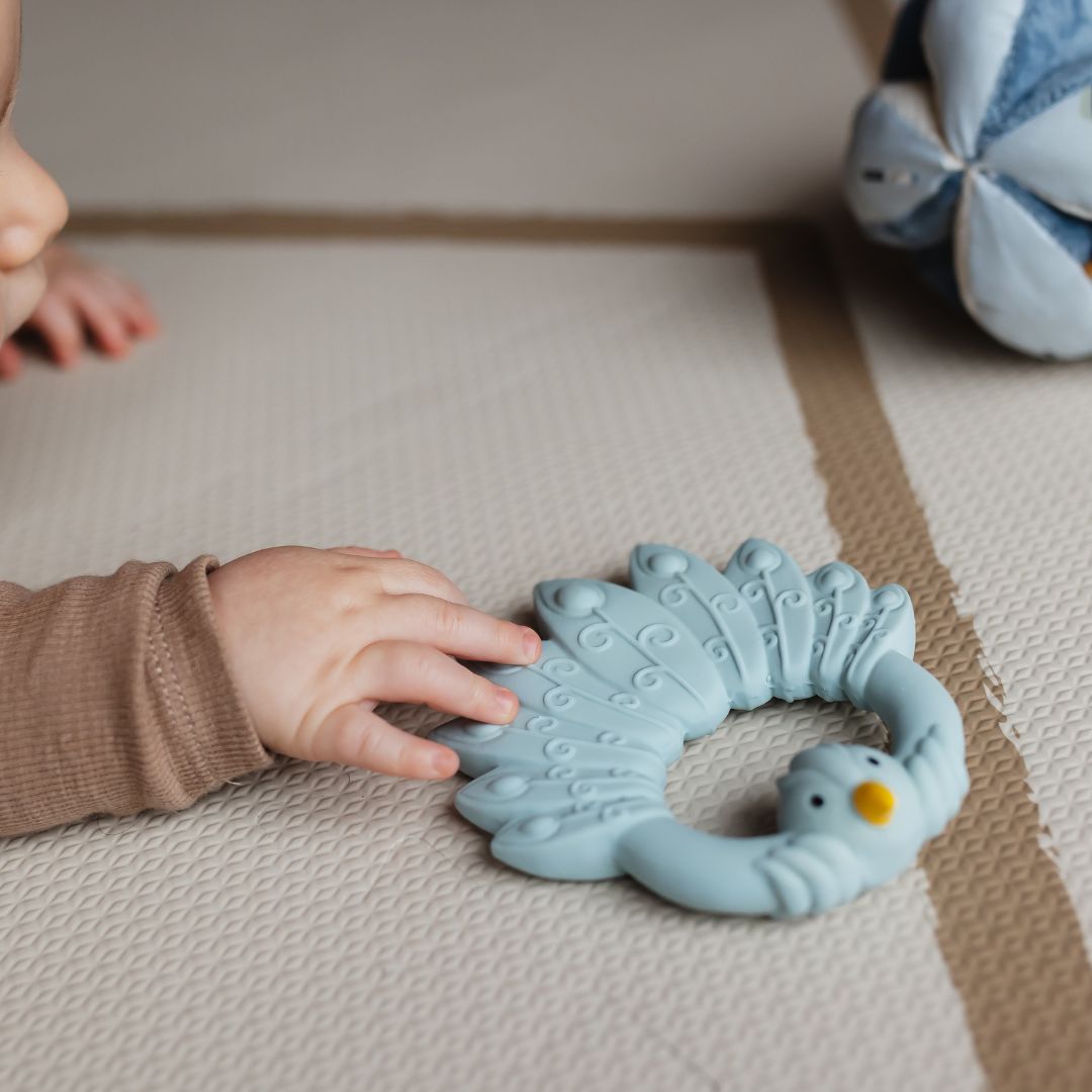 Natuurrubber bijtring in de vorm van een pauw van Natruba in de kleur licht blauw