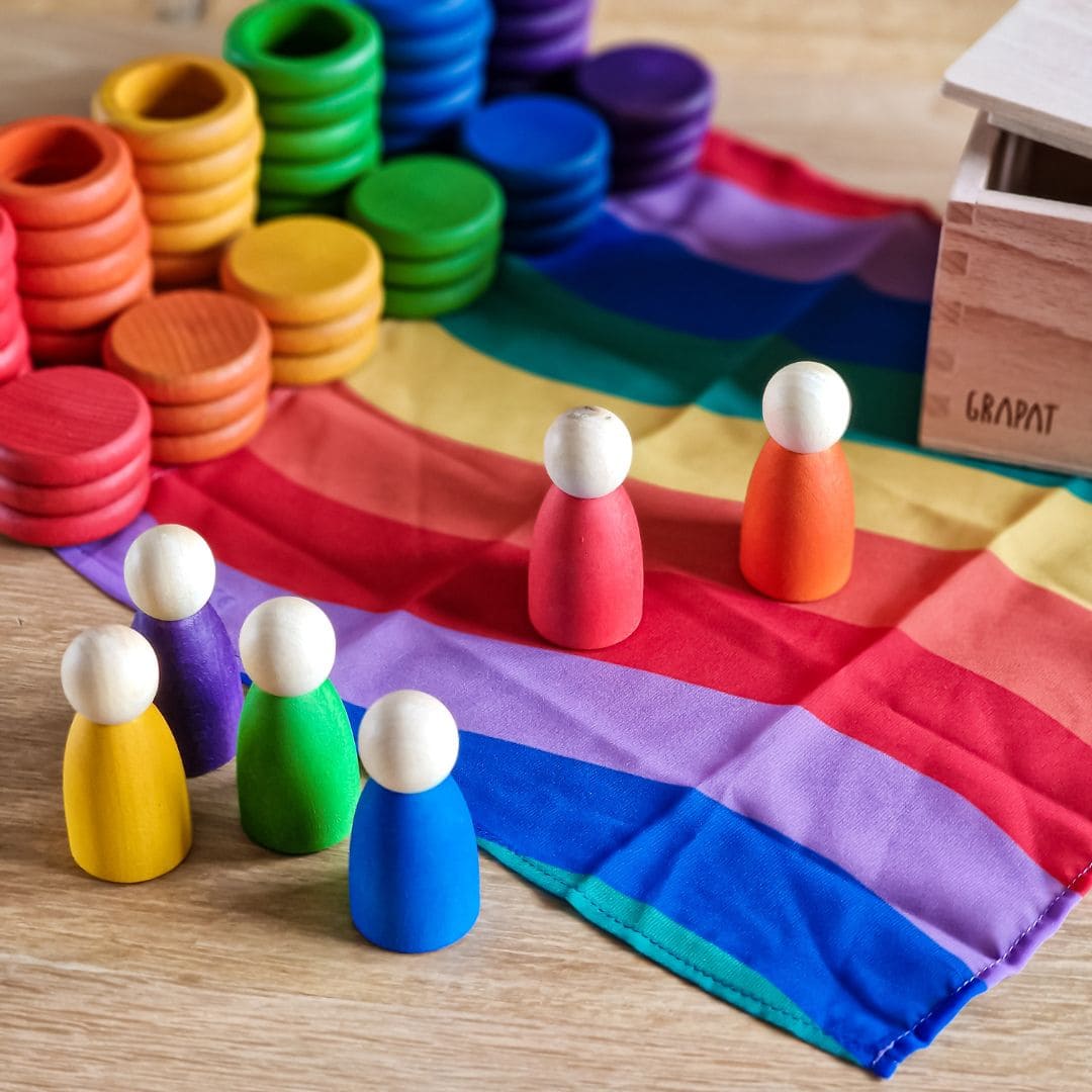 Open einde starterspeelset voor 0-2 jaar met objectpermanentiebox, speeldoek en grapat houten ringen, munten en poppetjes om objectpermantie te stimuleren en uit te nodigen tot fantasierijk en zelfstandig spel