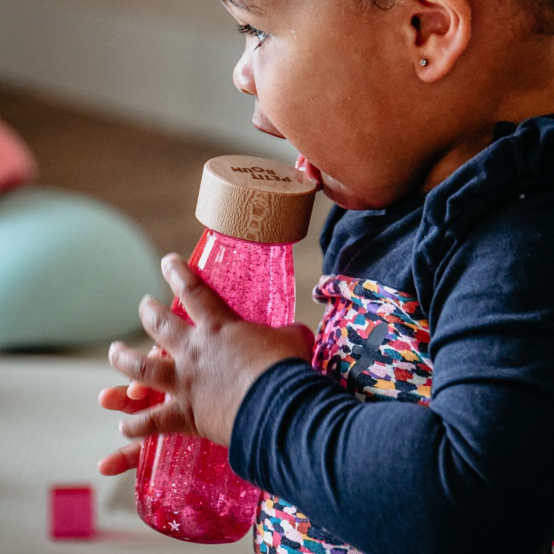 Petit Boum sensory bottle sensorische fles met glitters, pailletten en pompons in de kleur roze