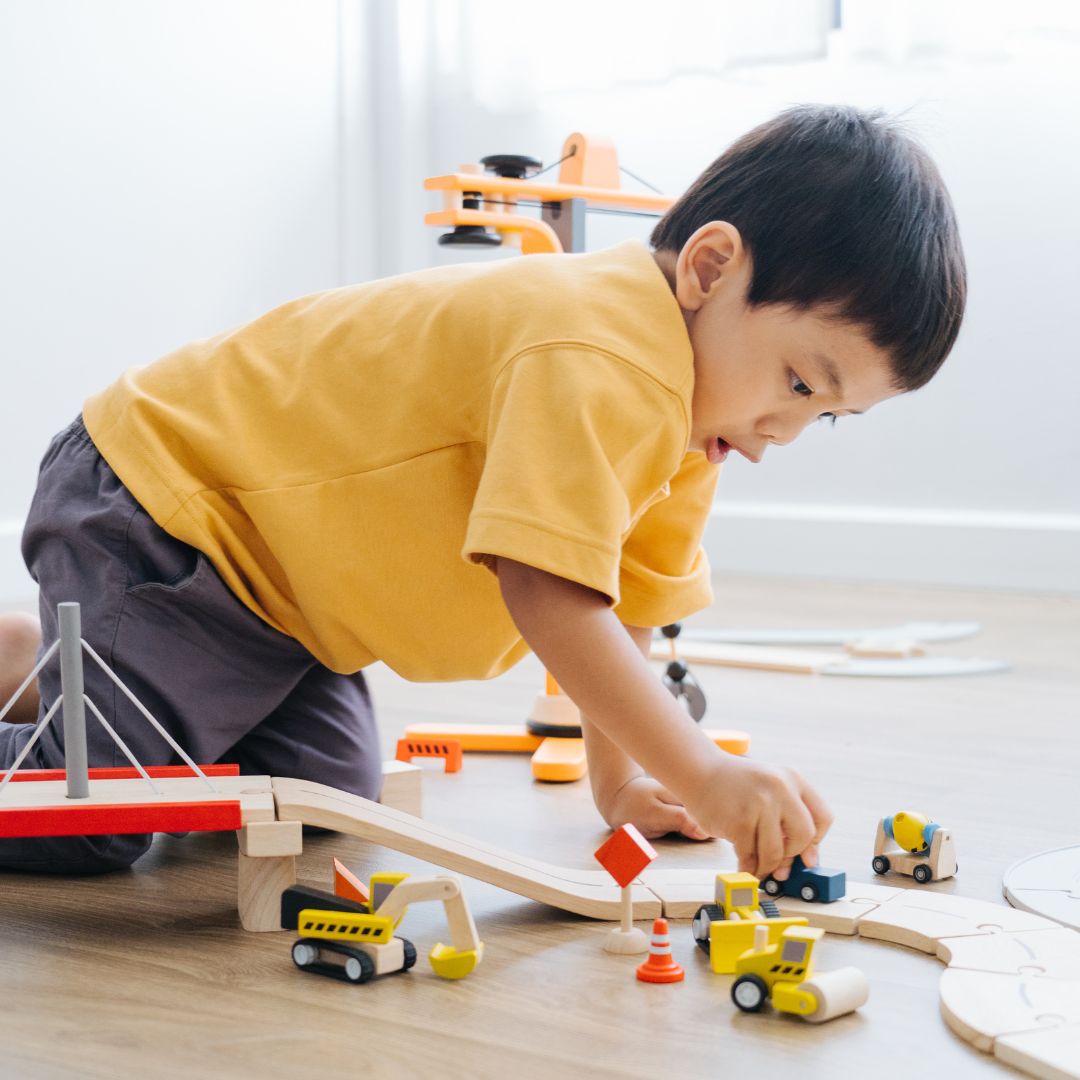 spelend kind met houten bouwvoertuigen van Plantoys