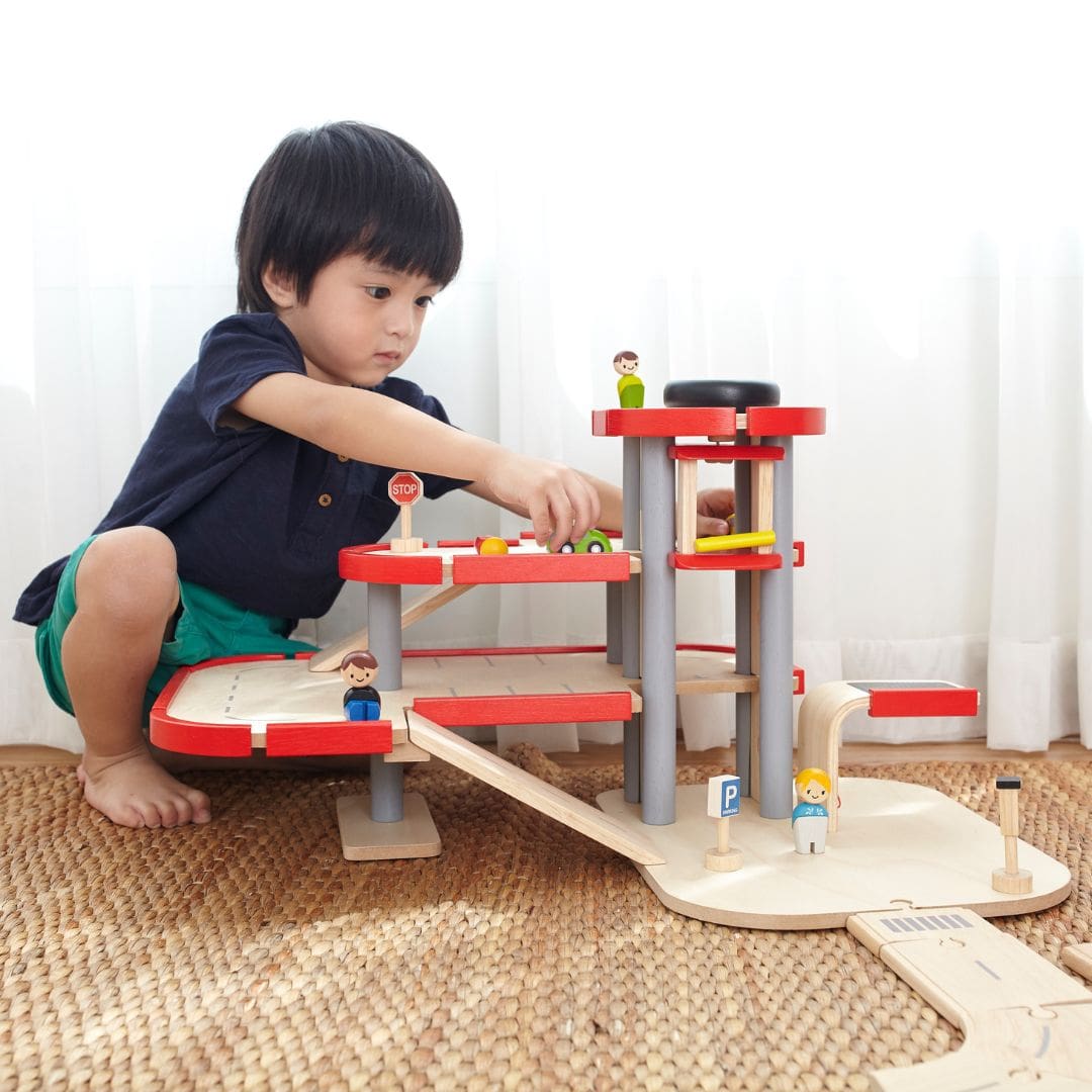 Spelend kind met parkeergarage van Plantoys