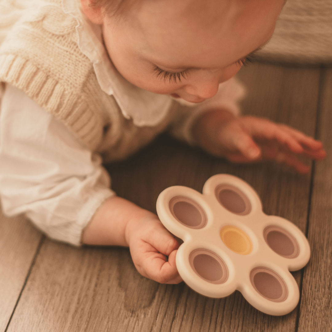 Mushie sensorisch speelgoed press toy bloem lila en geel