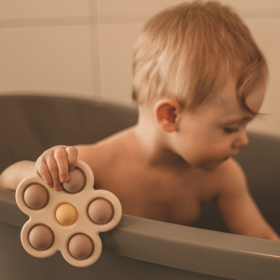 Mushie sensorisch speelgoed press toy bloem lila en geel