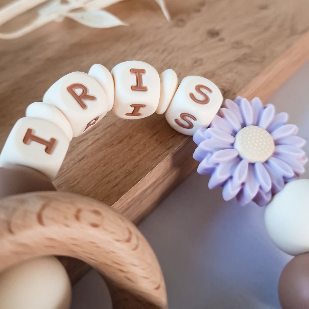 Bijtring met naam siliconen in de kleur lila met bloem kraal handgemaakt kraamcadeau met naam van Studio Bambacht