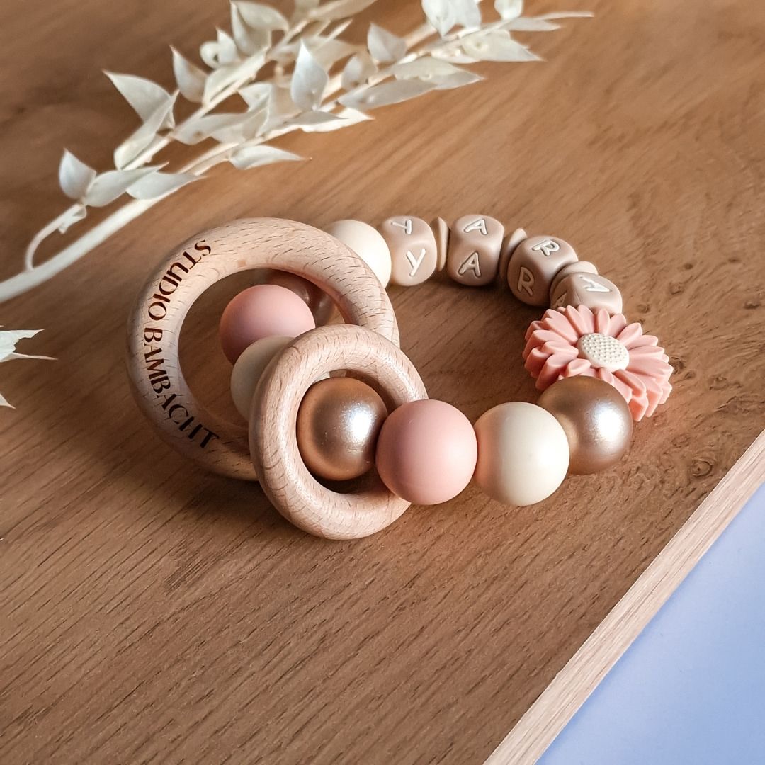 Bijtring met naam madelief in de kleur zalmroze handgemaakt door Iris van Studio Bambacht