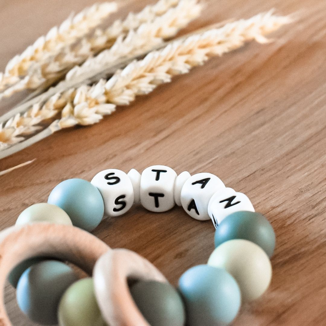 Bijtring met naam in de kleuren blauw en groen handgemaakt kraamcadeau met naam door Iris van Studio Bambacht