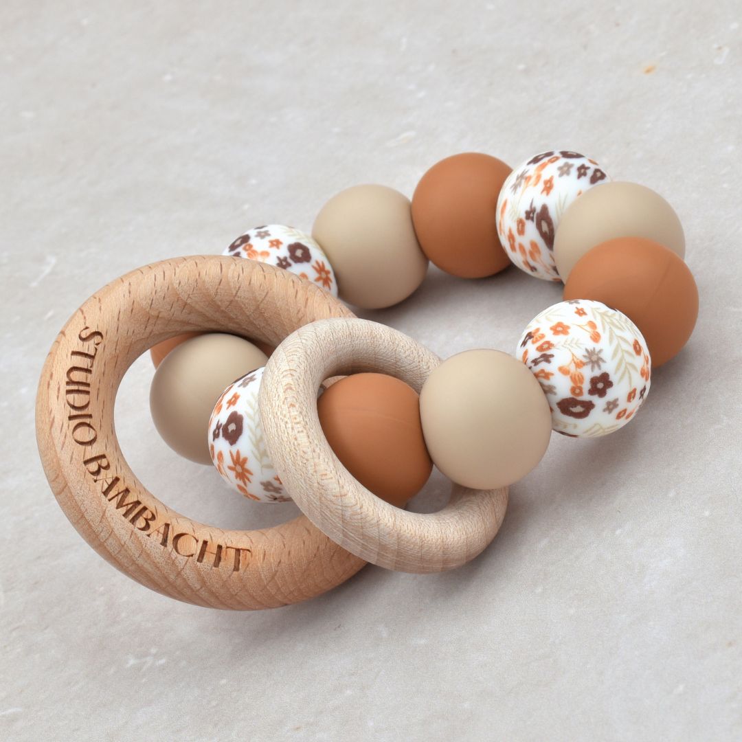 Bijtring van Studio Bambacht met bloemenprint in de kleur roest en beige en twee houten ringen