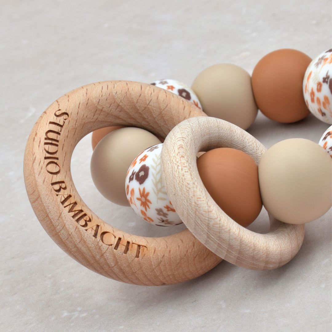 Bijtring van Studio Bambacht met bloemenprint in de kleur roest en beige en twee houten ringen