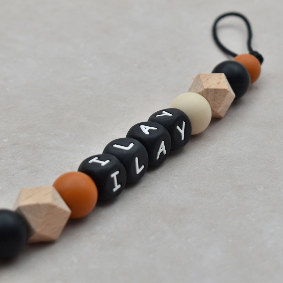 Speenkoord met naam van Studio Bambacht in de kleuren zwart, roest en beige