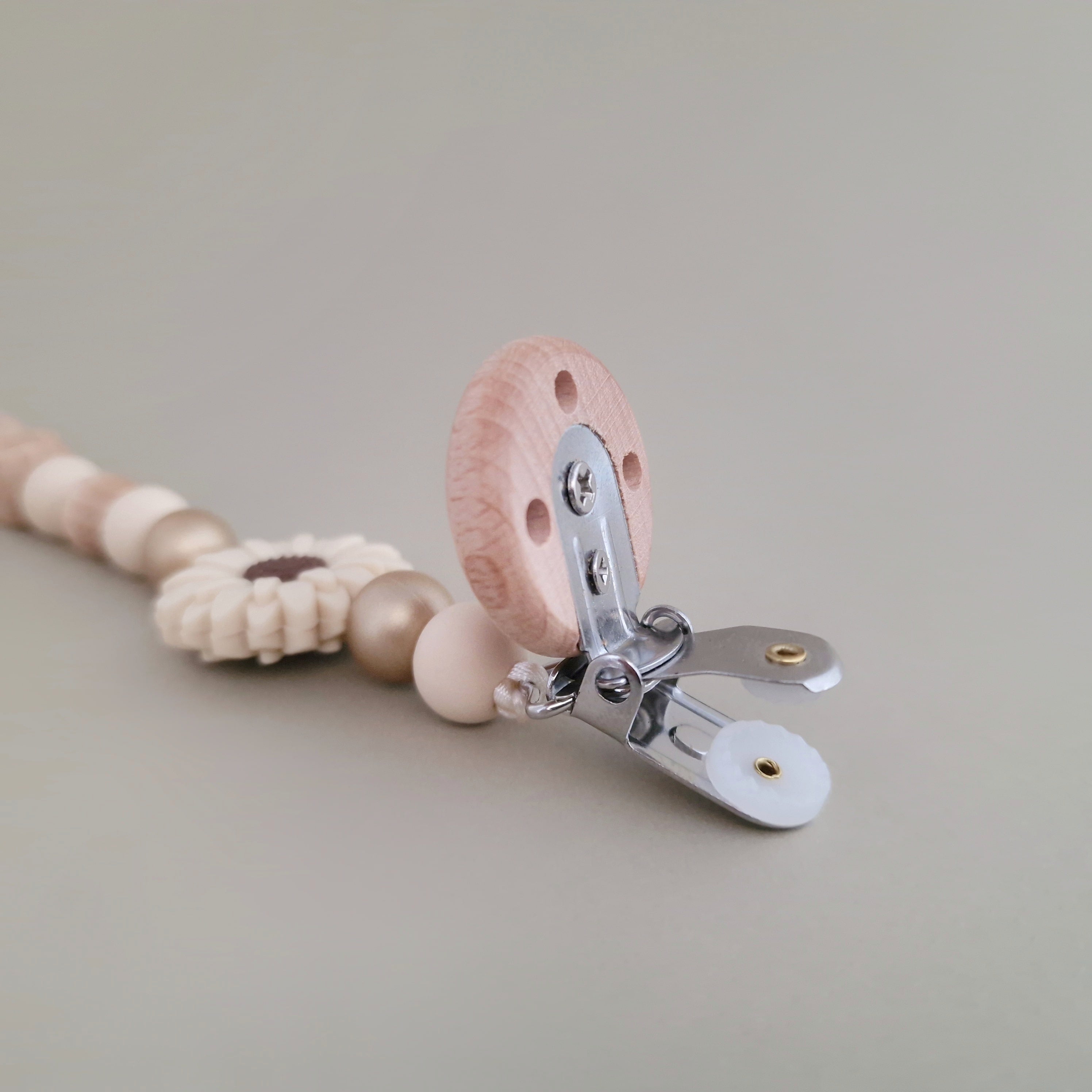 Speenkoord met naam van Studio Bambacht met bloem in de kleuren beige en goud