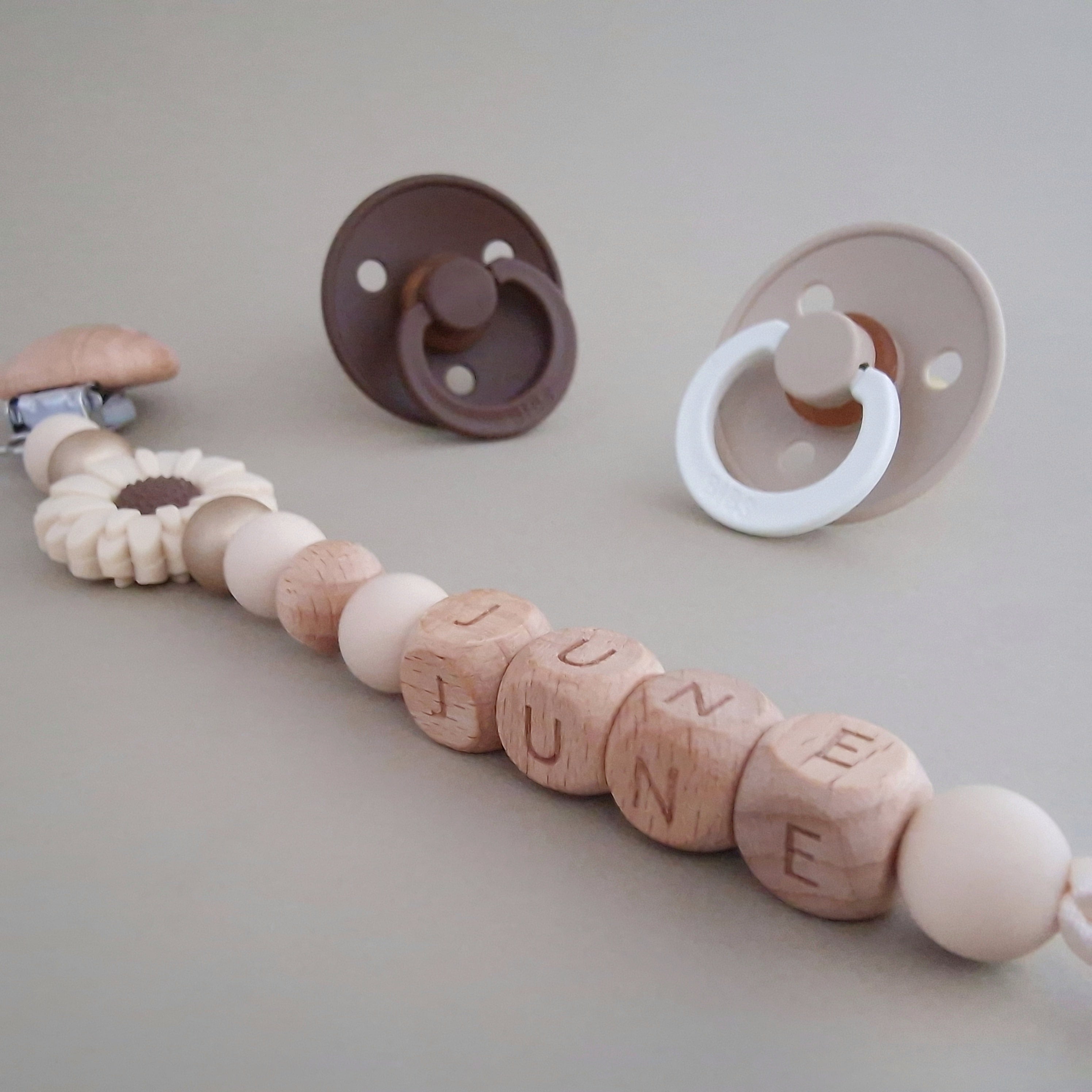 Speenkoord met naam van Studio Bambacht met bloem in de kleuren beige en goud