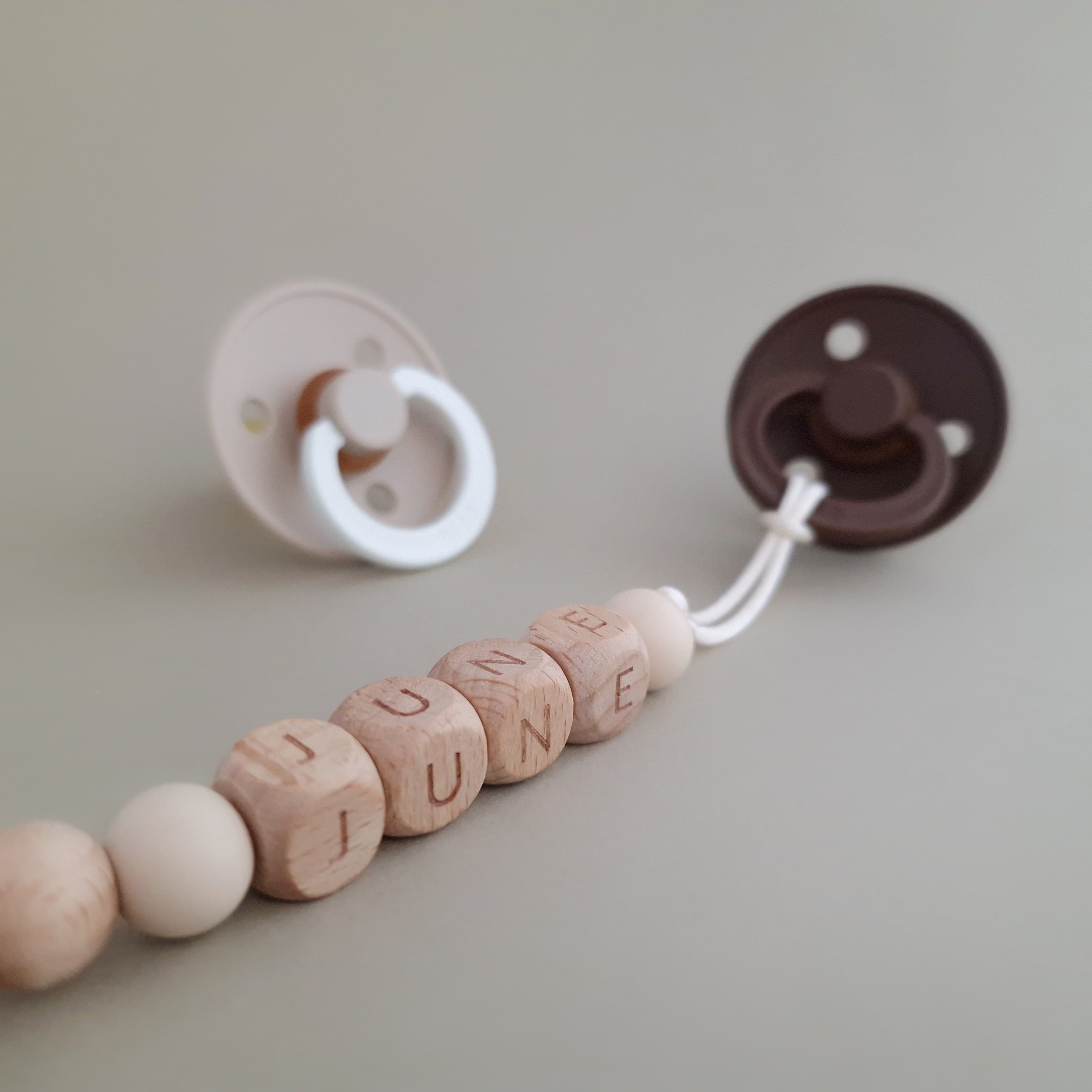 Speenkoord met naam van Studio Bambacht met bloem in de kleuren beige en goud