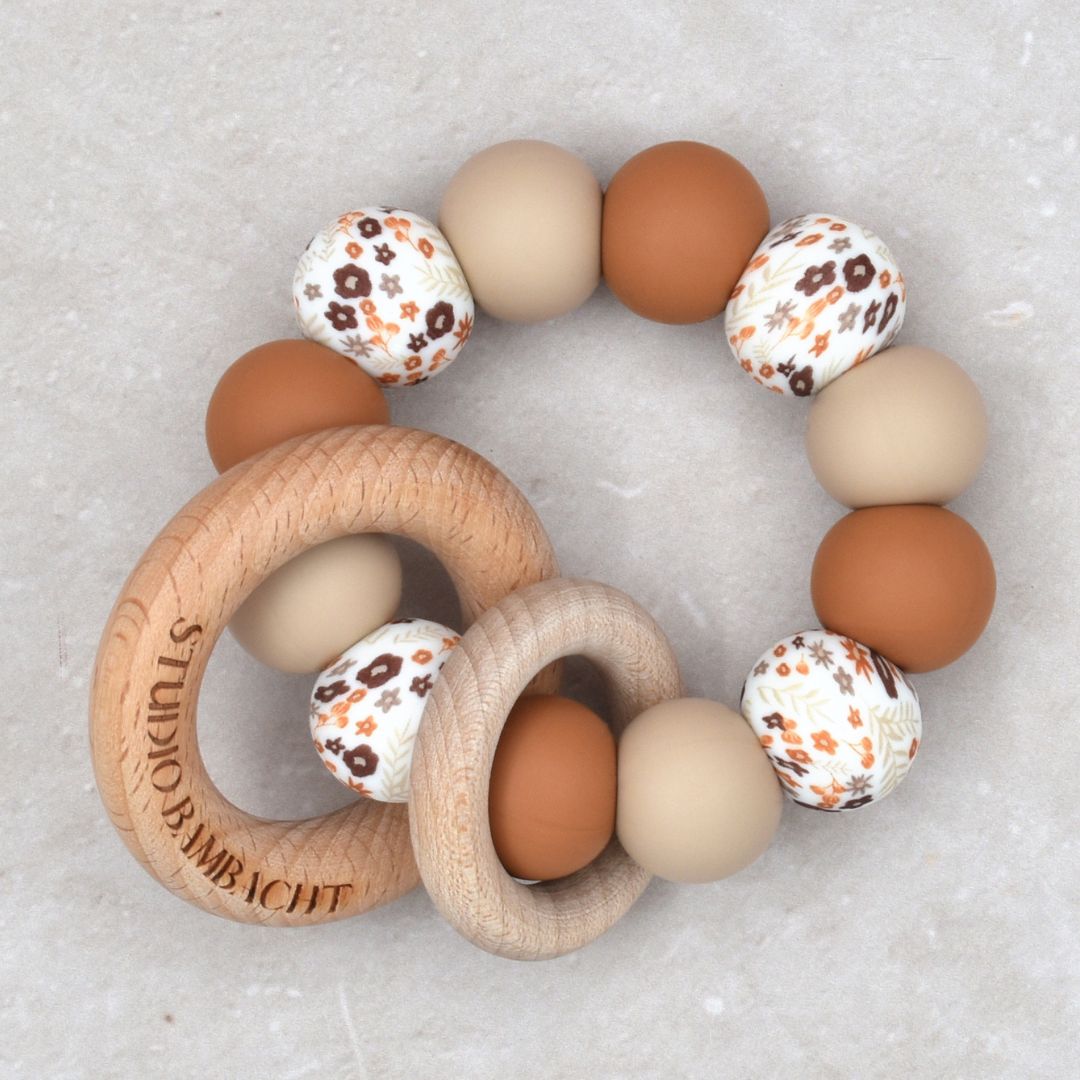 Bijtring van Studio Bambacht met bloemenprint in de kleur roest en beige en twee houten ringen